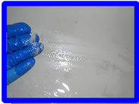 風呂職人が湯垢を分解している写真です。溶剤を塗布した後にこするとこうなります。
